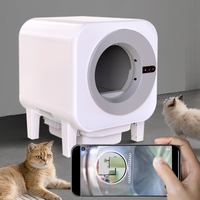 X27 self-cleaning cat litter box with a smartphone displaying the live pet camera view inside, two cats watching nearby