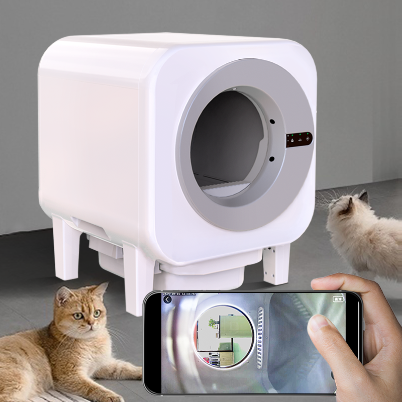 X27 self-cleaning cat litter box with a smartphone displaying the live pet camera view inside, two cats watching nearby