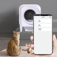 Hand holding a smartphone showing the X27 litter box app listing multi-cat profiles DODO