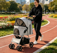Man jogging on a red running track while pushing the gray pet stroller past flower beds