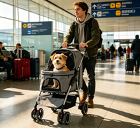 Man pushing the gray pet stroller through an airport terminal with a small terrier inside the carrier
